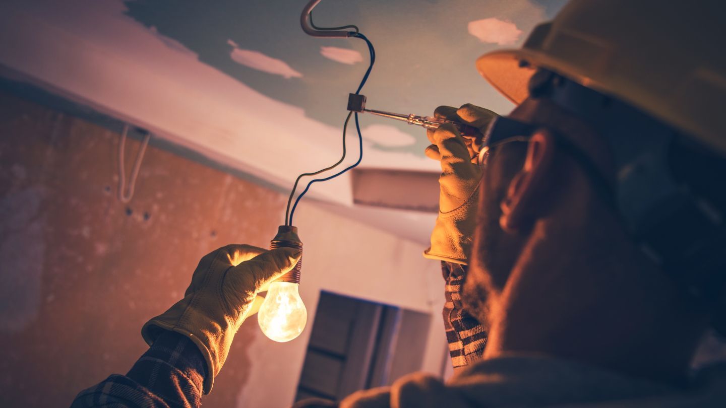 A metal roof with a skylight against a bright blue sky.
