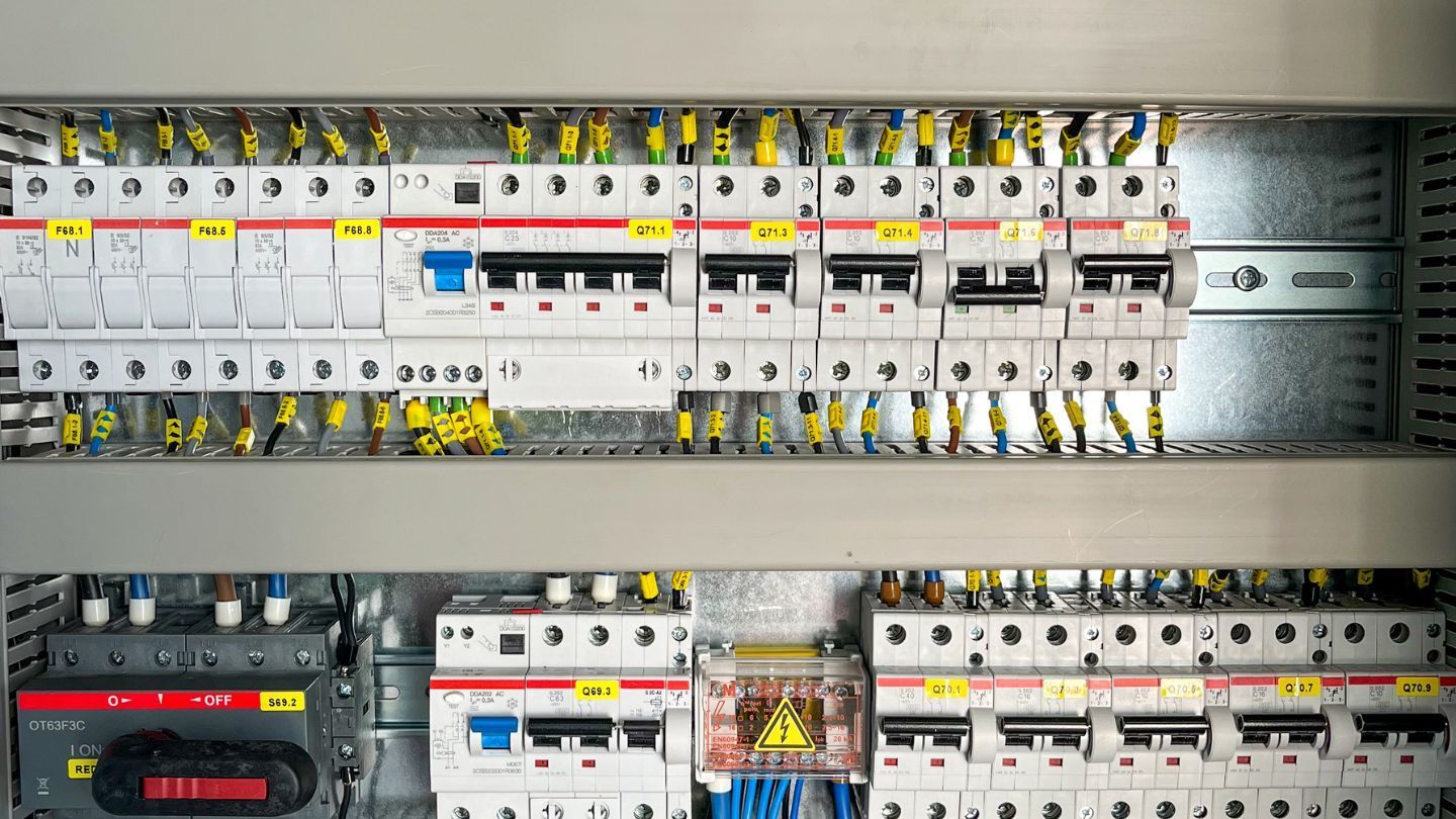 A metal roof with a skylight against a bright blue sky.