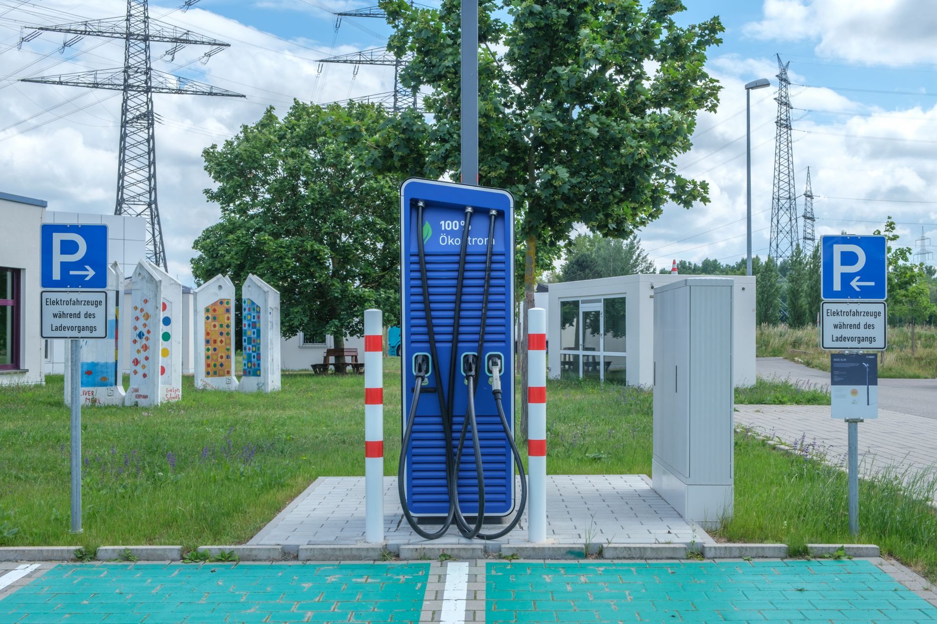 Blue public EV charging station in a parking area with parking signs and power lines in the background