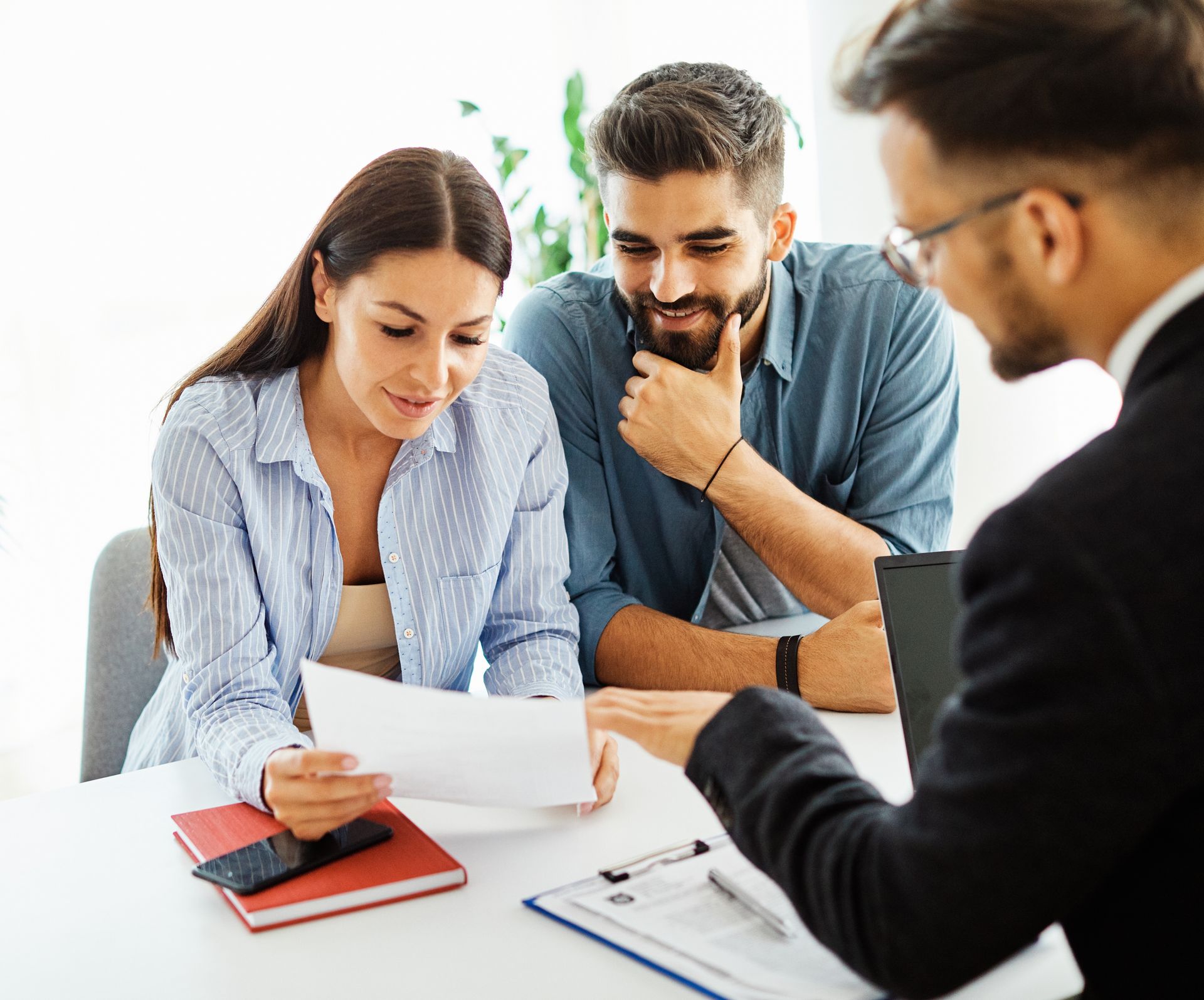 A man and a woman are sitting at a table looking at a piece of paper.