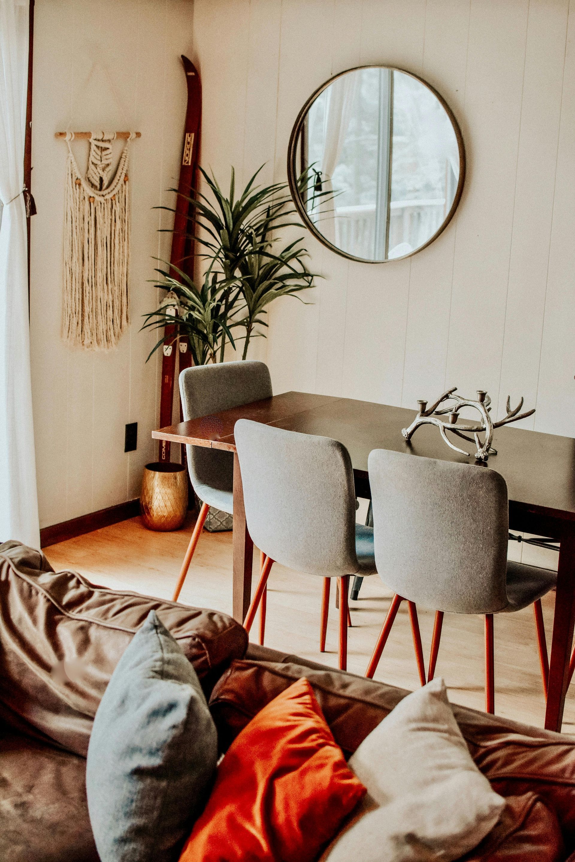 A living room with a couch , chairs , a table and a mirror.