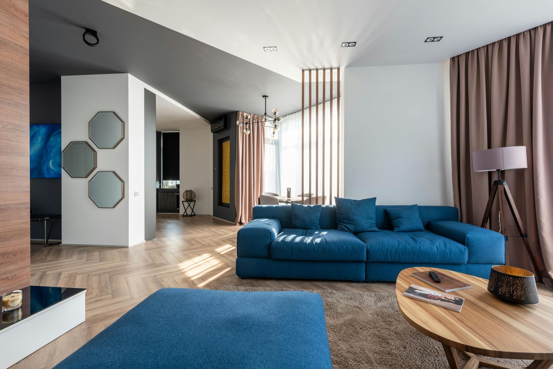 A living room with a blue couch and a wooden table.