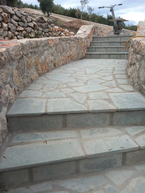 A stone walkway with stairs leading up to a stone wall