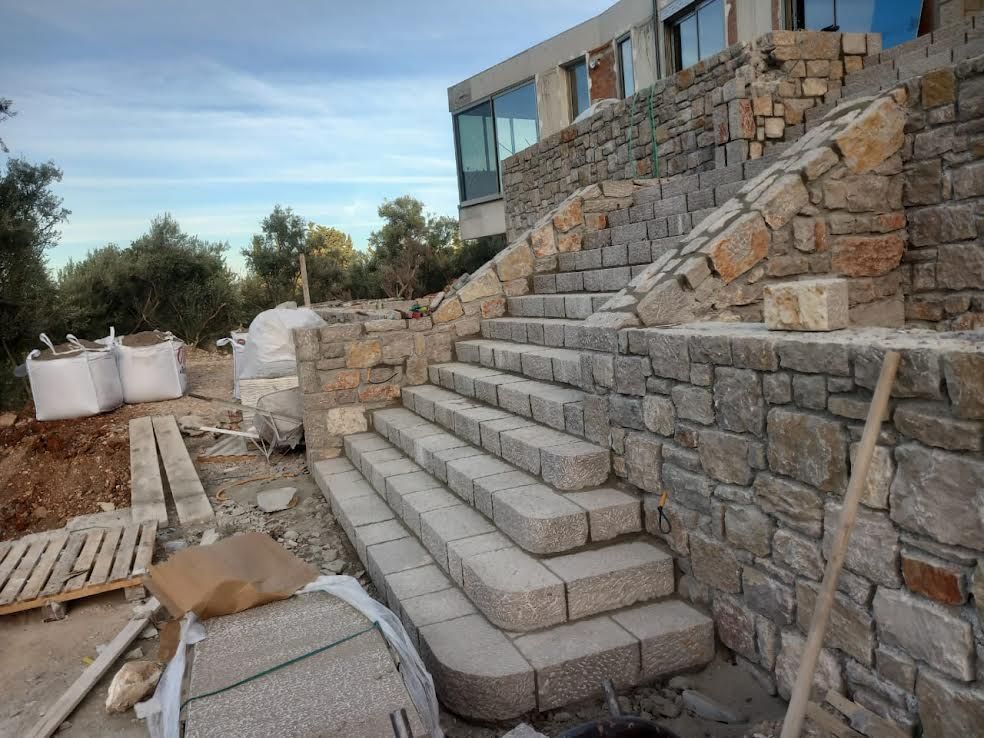 A stone staircase is being built in front of a building