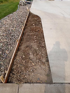 A concrete driveway is being built next to a gravel path.