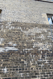 A close up of a brick wall with a window