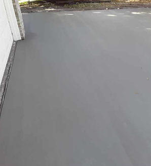 A gray concrete floor next to a white building.