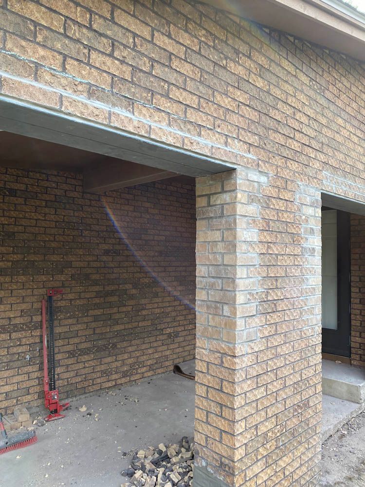 A brick building under construction with a brick wall and pillars.