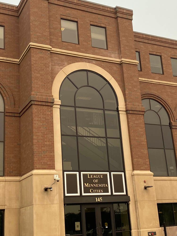 A large brick building with arched windows and a sign that says leases in minnesota