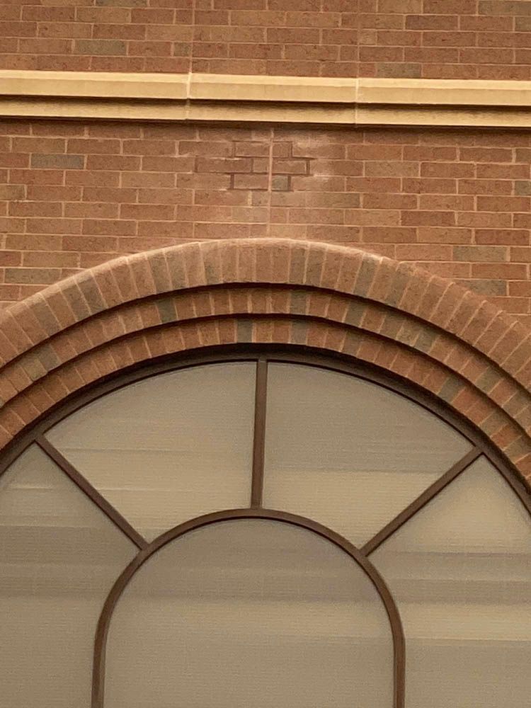 A brick building with a round window on the side