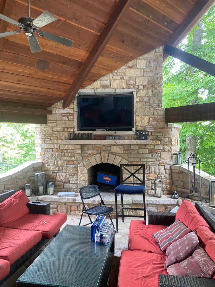 A living room with a fireplace , couch , table and television.