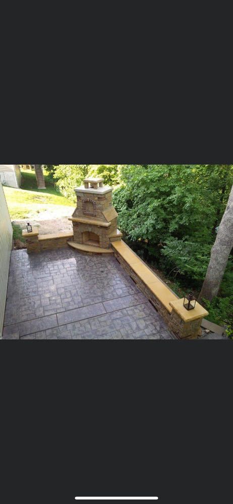 A patio with a fireplace and a bench in the backyard.