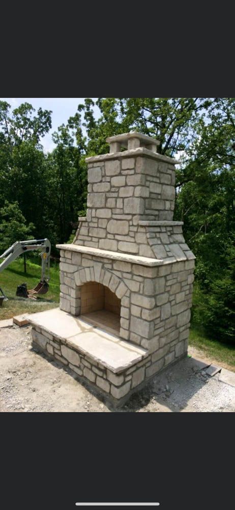 A stone fireplace is sitting on top of a dirt hill.