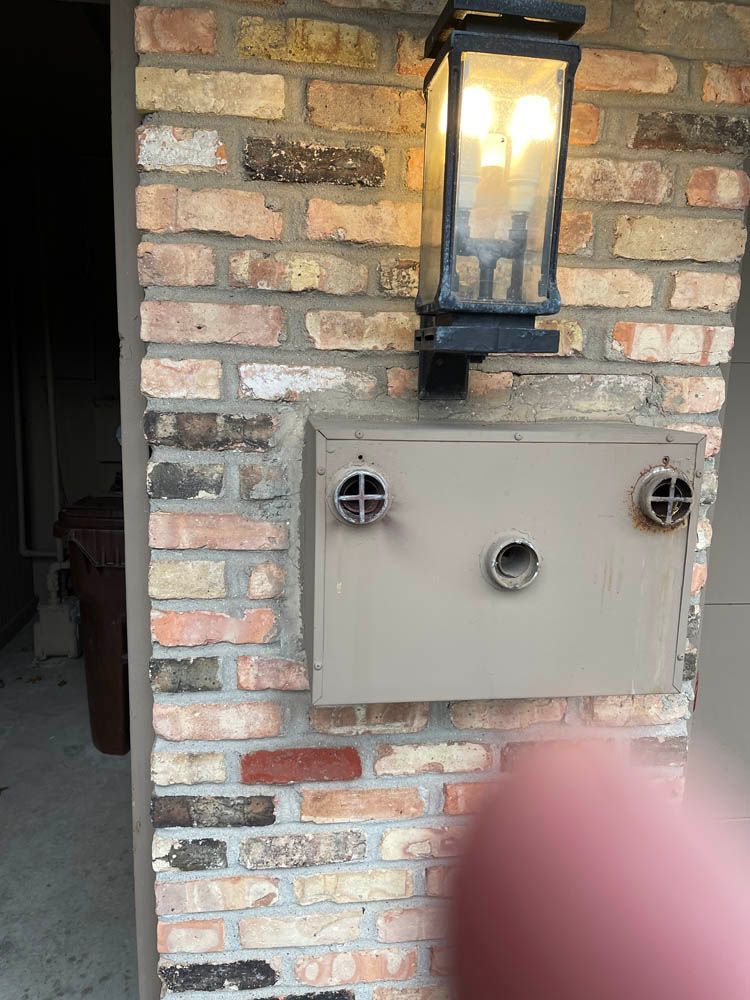 A brick wall with a mailbox and a light on it.