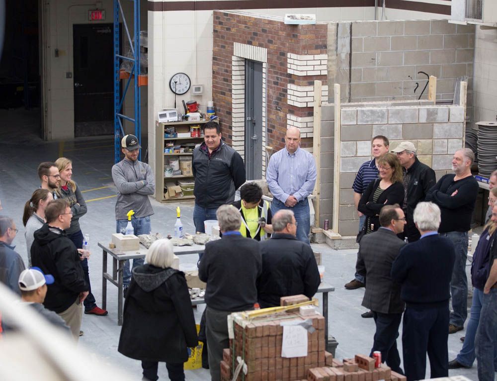 A group of people are standing around a table in a building.