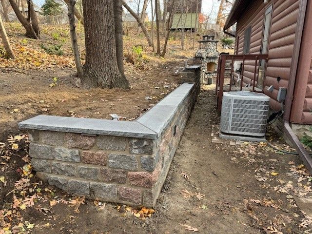 A house with a brick wall and an air conditioner in front of it