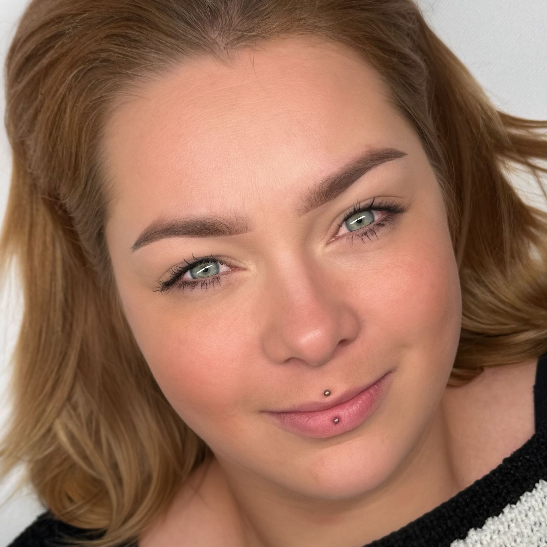 Eine Nahaufnahme des Gesichts einer Frau mit einem Piercing in ihrer Lippe