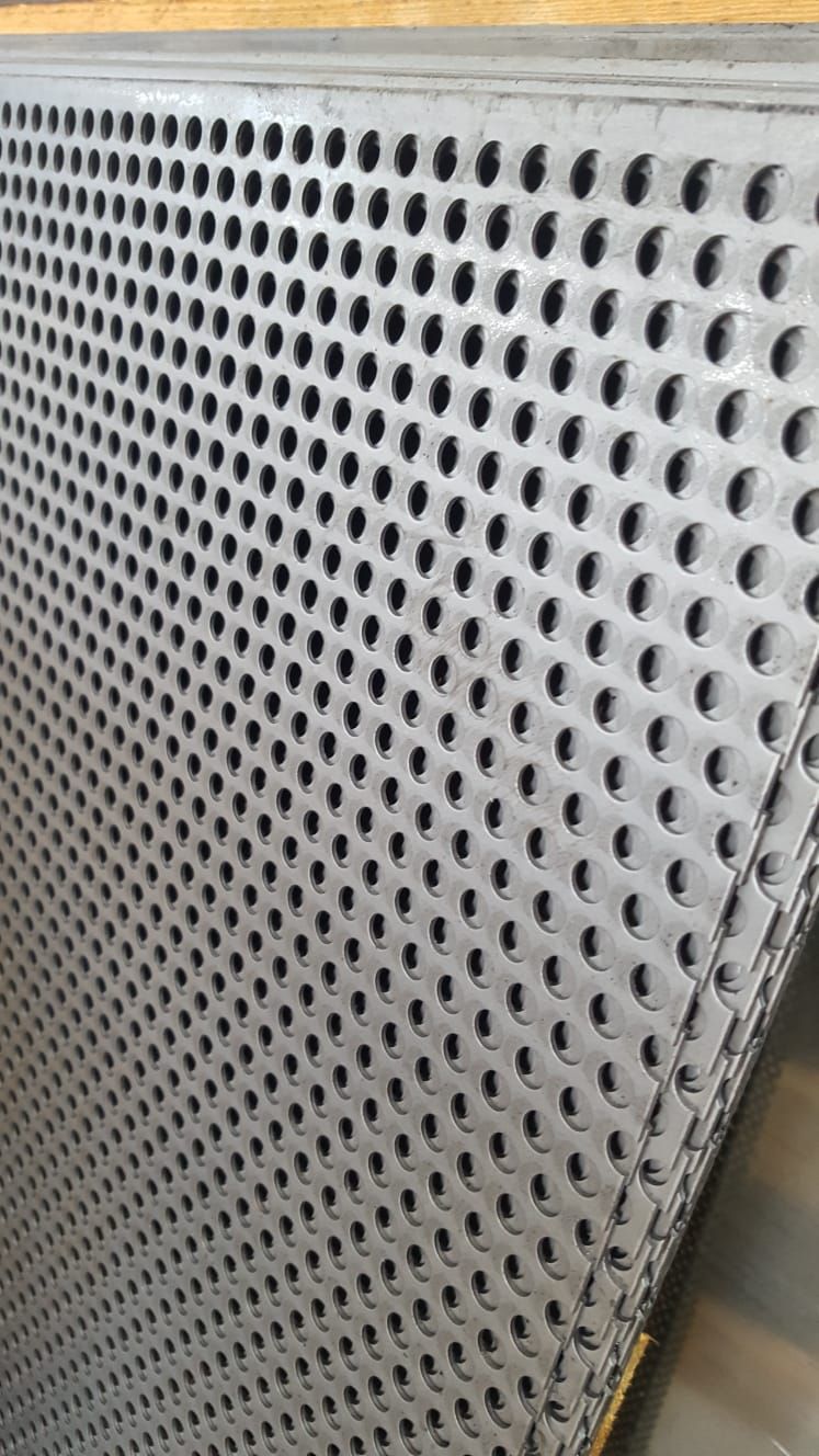 Primo piano di una lamiera perforata con dei fori.