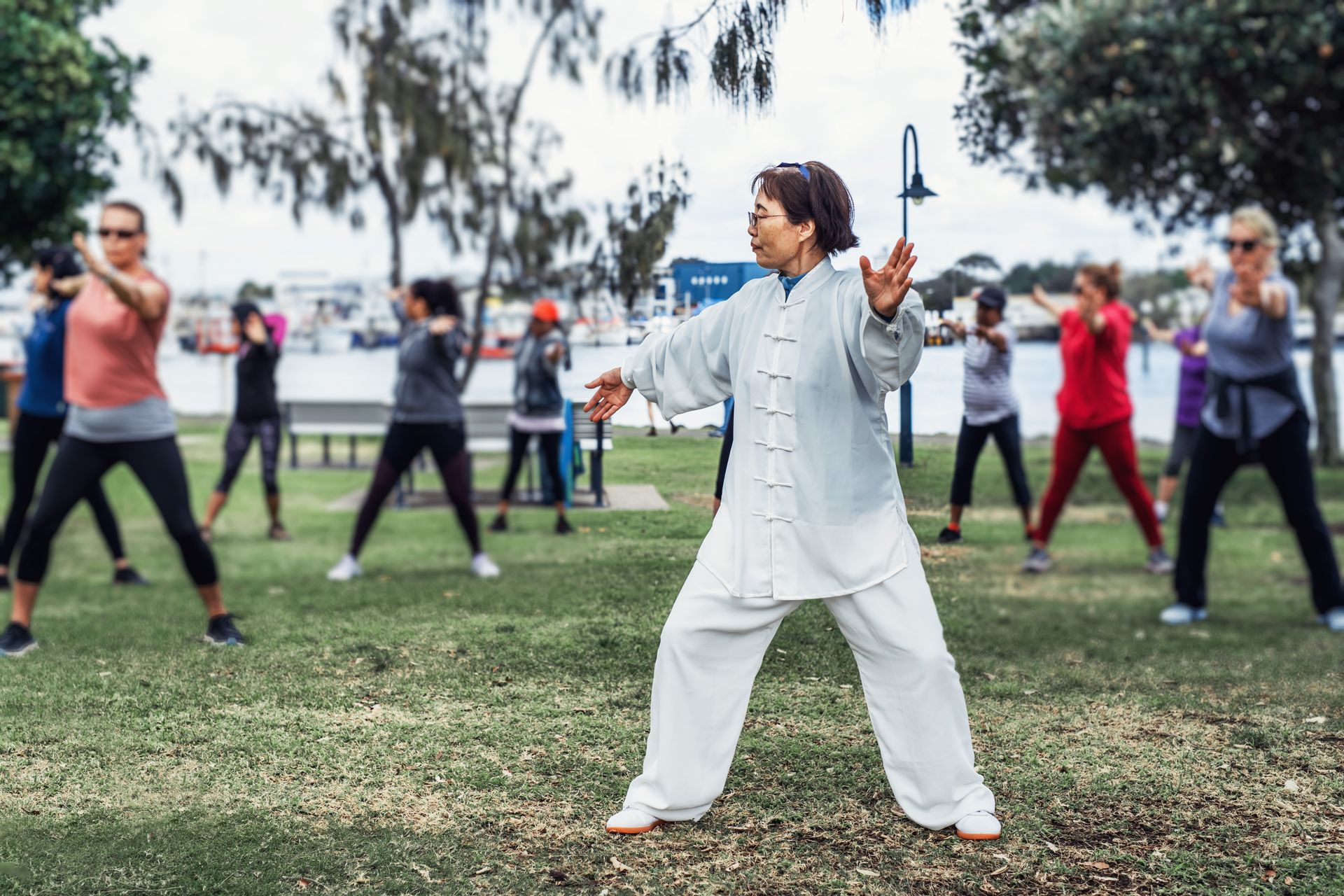 A group of people are practicing tai chi in a park.