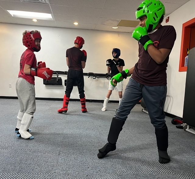 A man wearing green boxing gloves and a green helmet