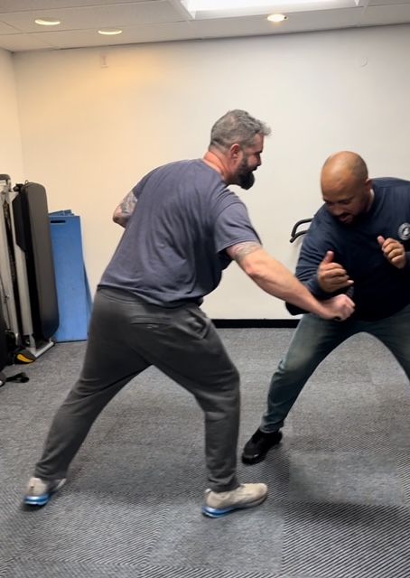 Two men are practicing martial arts in a gym