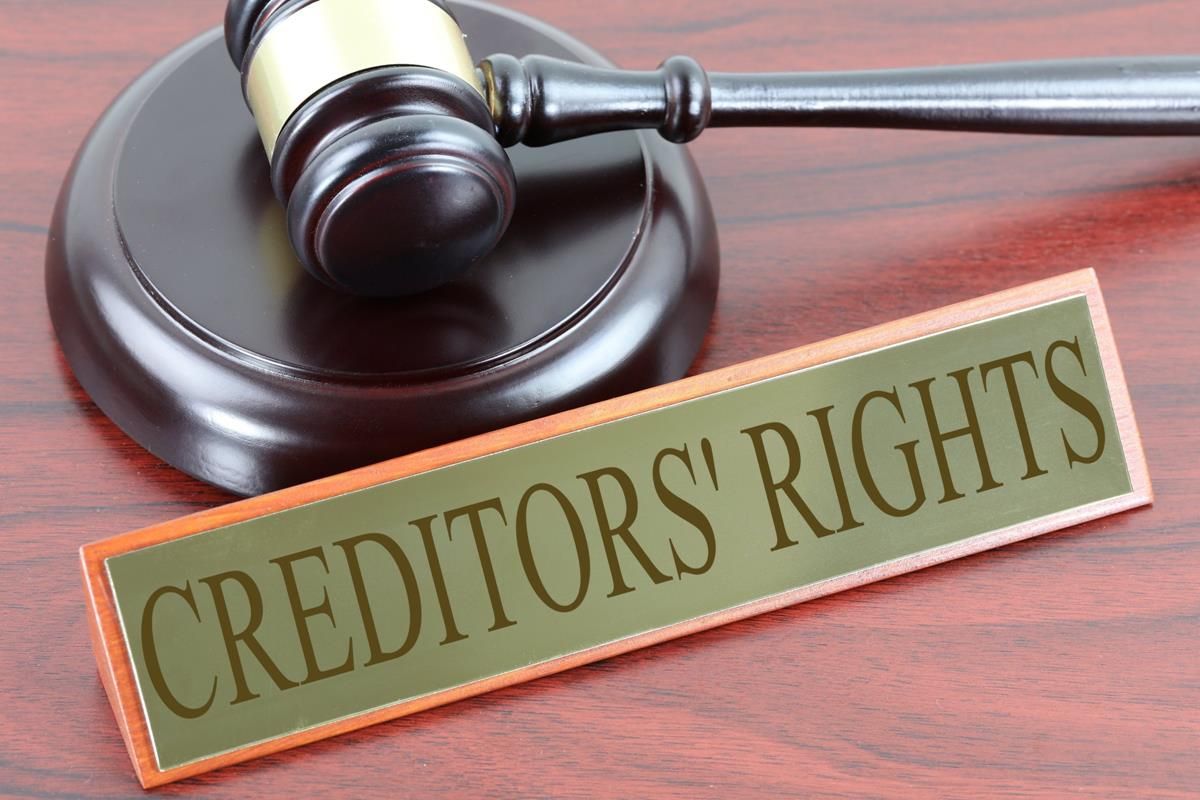 Gavel on a judge’s bench beside a sign reading “CREDITORS’ RIGHTS”