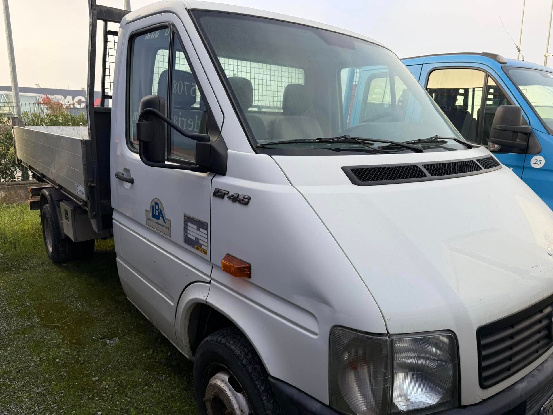 Un furgone bianco è parcheggiato accanto a un furgone blu.