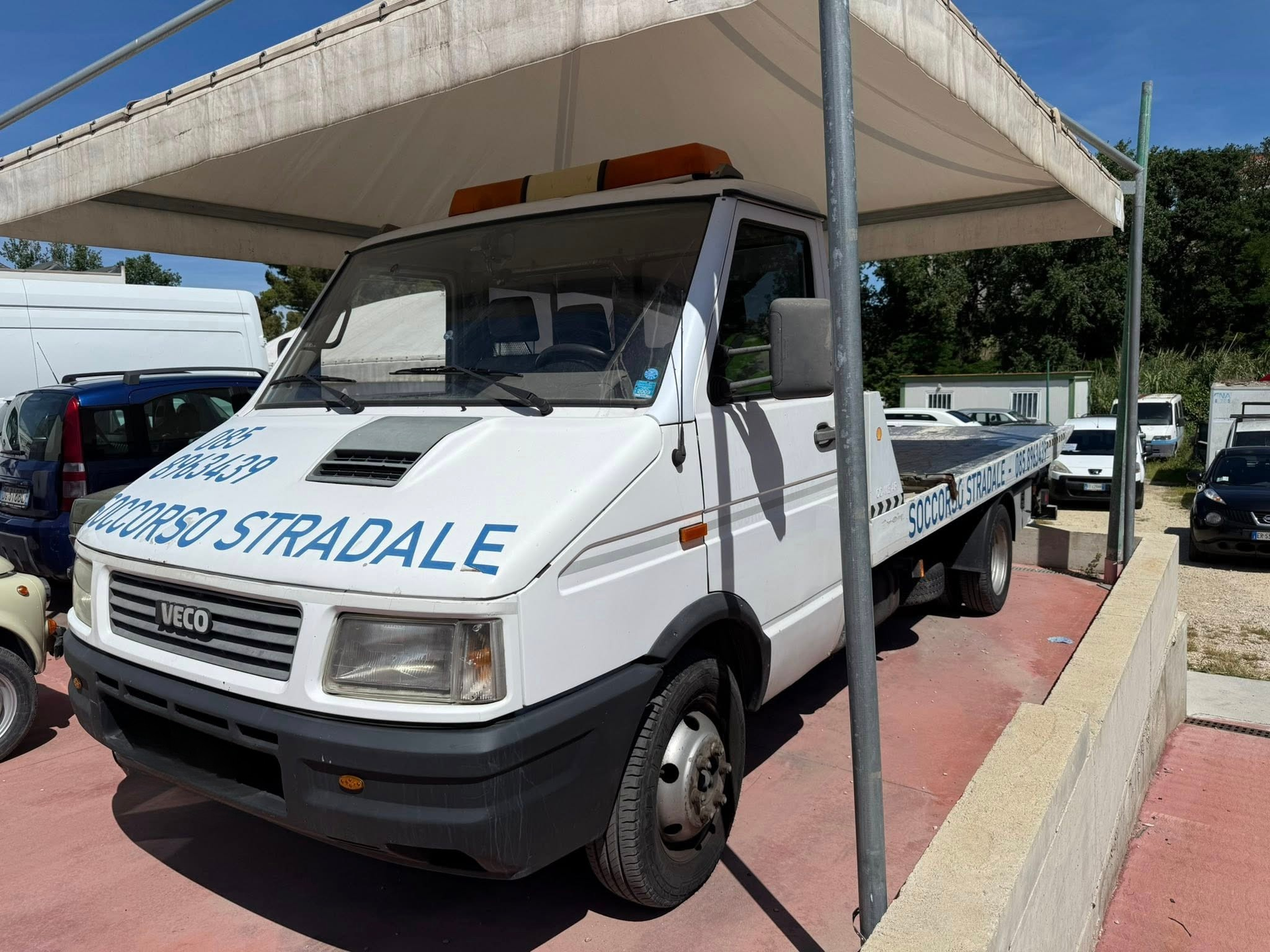 Un carro attrezzi bianco con la scritta stradale sul lato