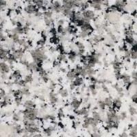 Et nærbillede af en hvid granitbordplade med sorte pletter.