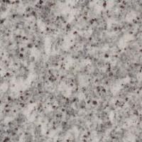 Et nærbillede af en hvid granitbordplade med sorte pletter.