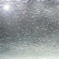 Et nærbillede af et vindue, hvor der kommer en masse vand ud af det.