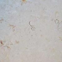 Et nærbillede af en hvid flise med et par små huller i.