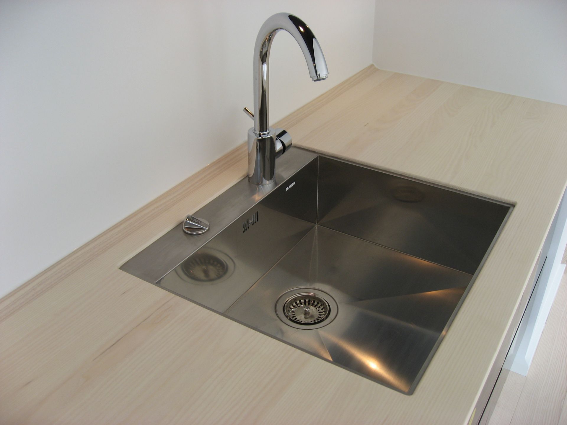 En køkkenvask i rustfrit stål med et armatur i krom