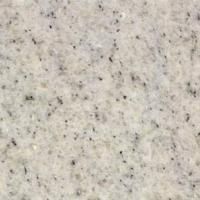 Et nærbillede af en hvid granitbordplade med sorte pletter.