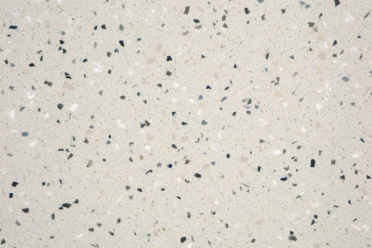 Et nærbillede af en hvid overflade med sorte pletter