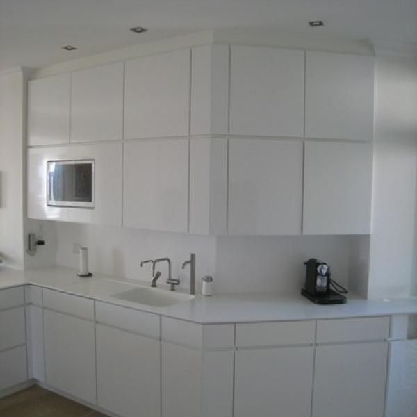 Et køkken med hvide skabe og en vask med tallet 71 på