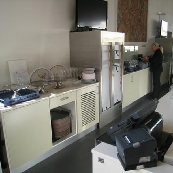 En kvinde står i et køkken og ser på en computerskærm