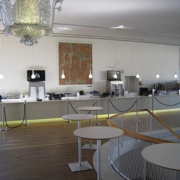 Et stort rum med borde og en lysekrone hængende fra loftet