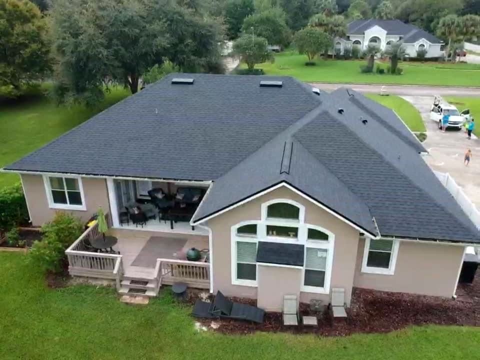 An aerial view of a house with a black roof