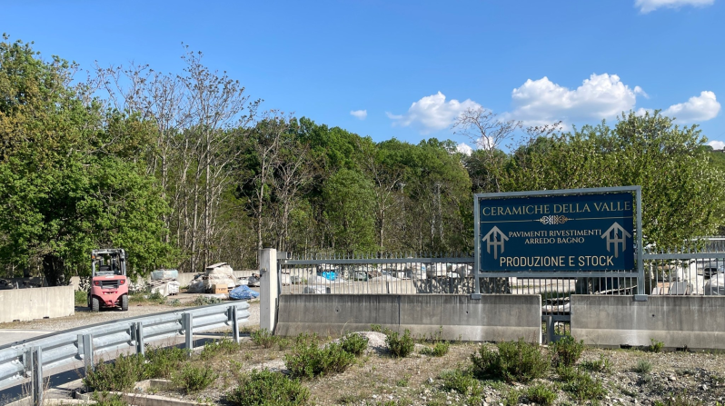 Un carrello elevatore percorre un'autostrada accanto a un cartello.
