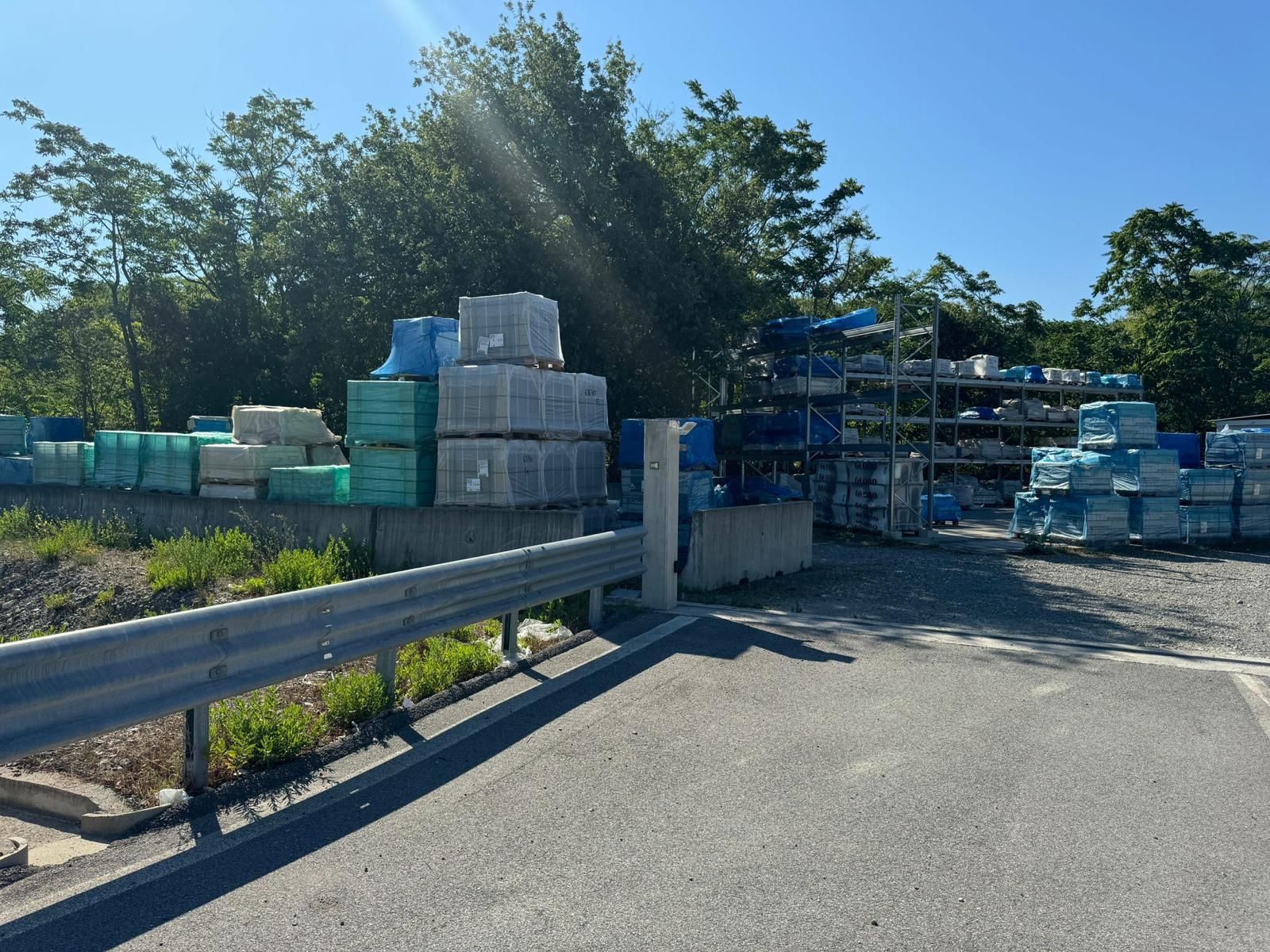 Molti container sono impilati uno sopra l'altro sul lato della strada.