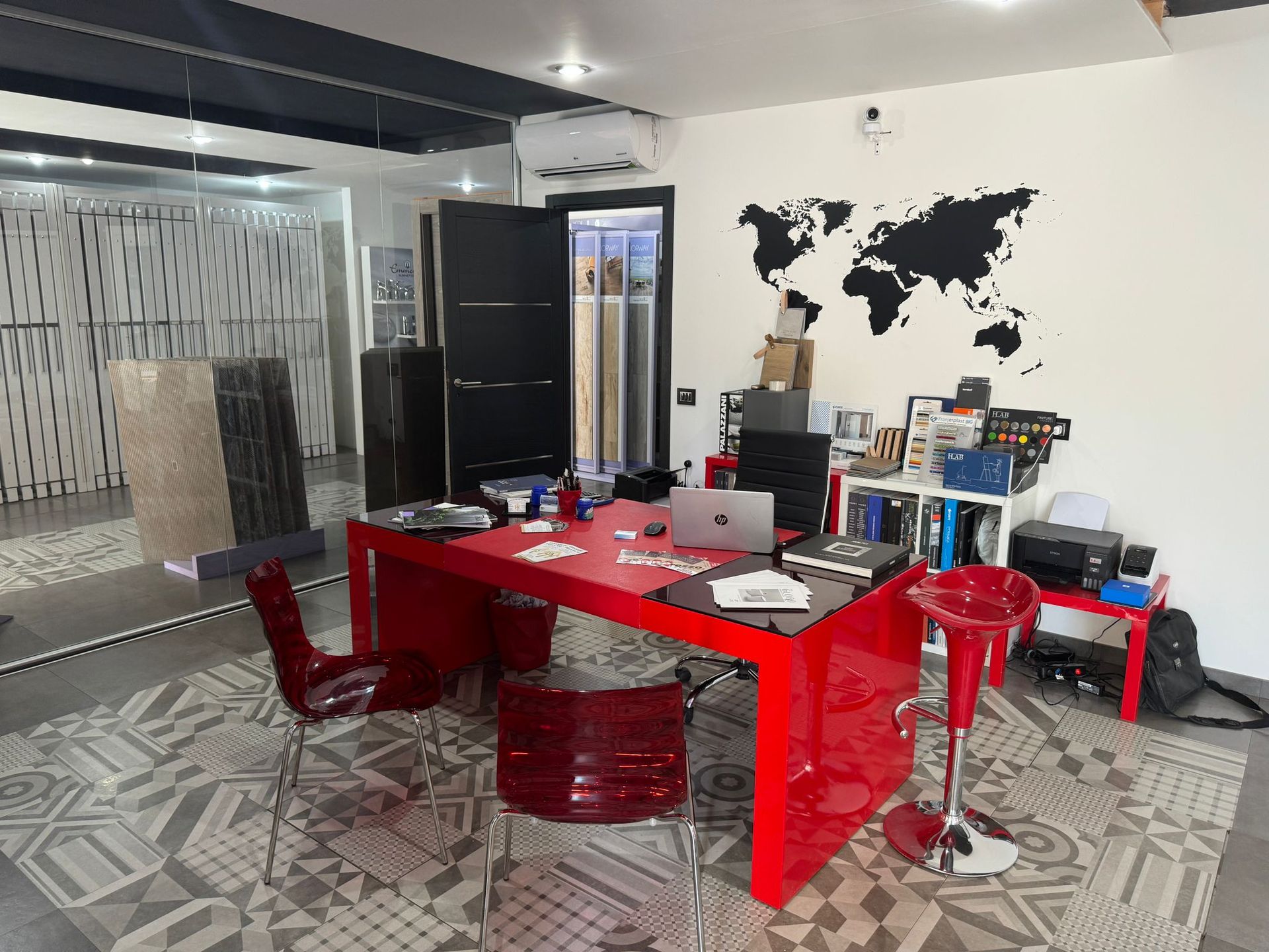 Una stanza con tavolo e sedie rosse e una mappa del mondo sul muro.