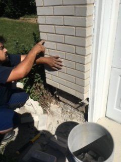 Professional Masonry Work Repairs — Man checking the brick wall for repairs in Lititz, PA