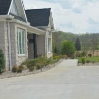 Suburban house exterior with a wide concrete driveway and landscaped front yard
