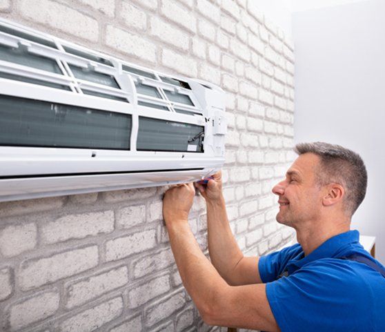 Repair Man Fixing Air Conditioner — Owatonna, MN — Central Heating & Air Conditioning of Owatonna