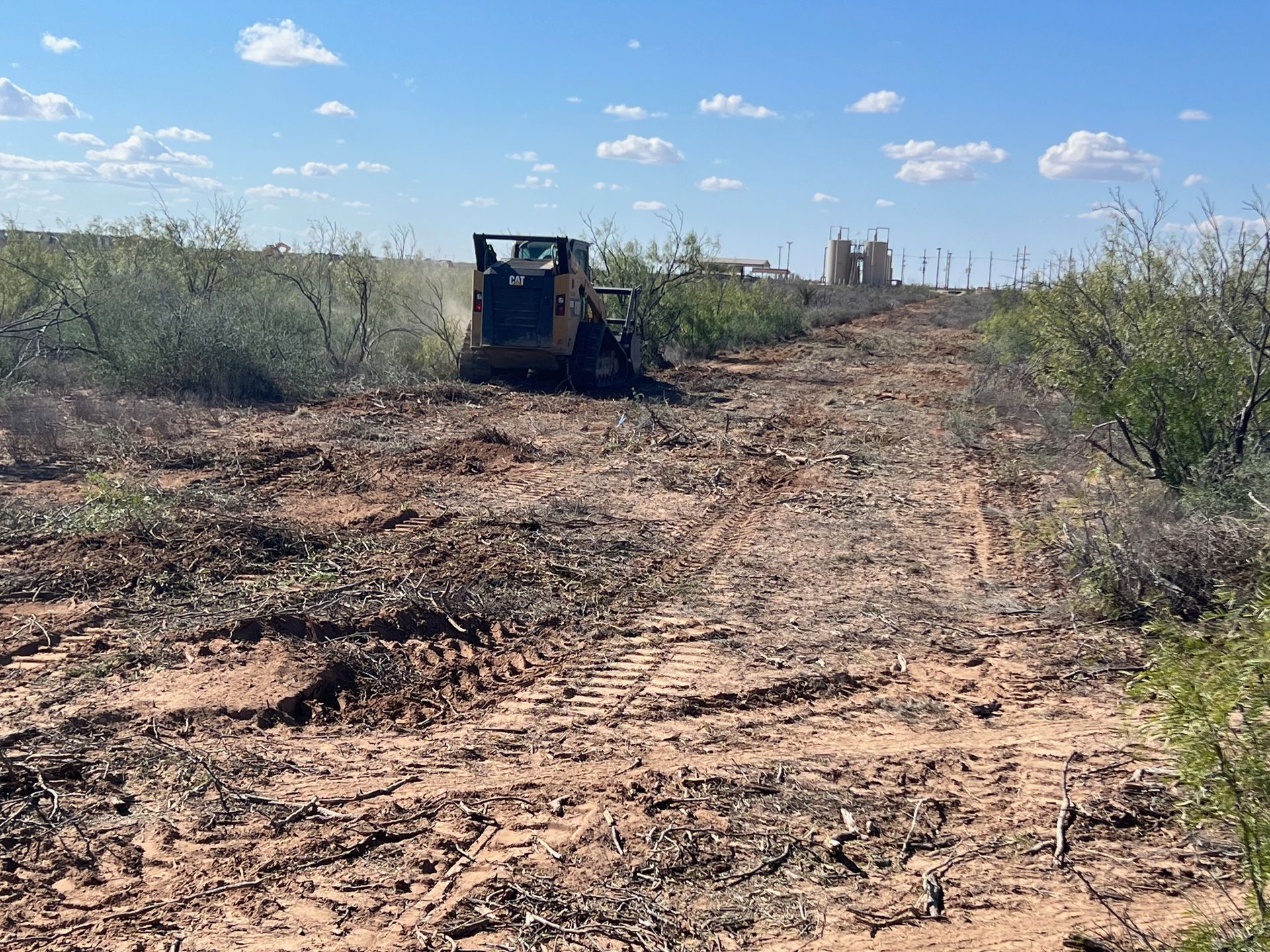 A bulldozer is driving through a dirt field.