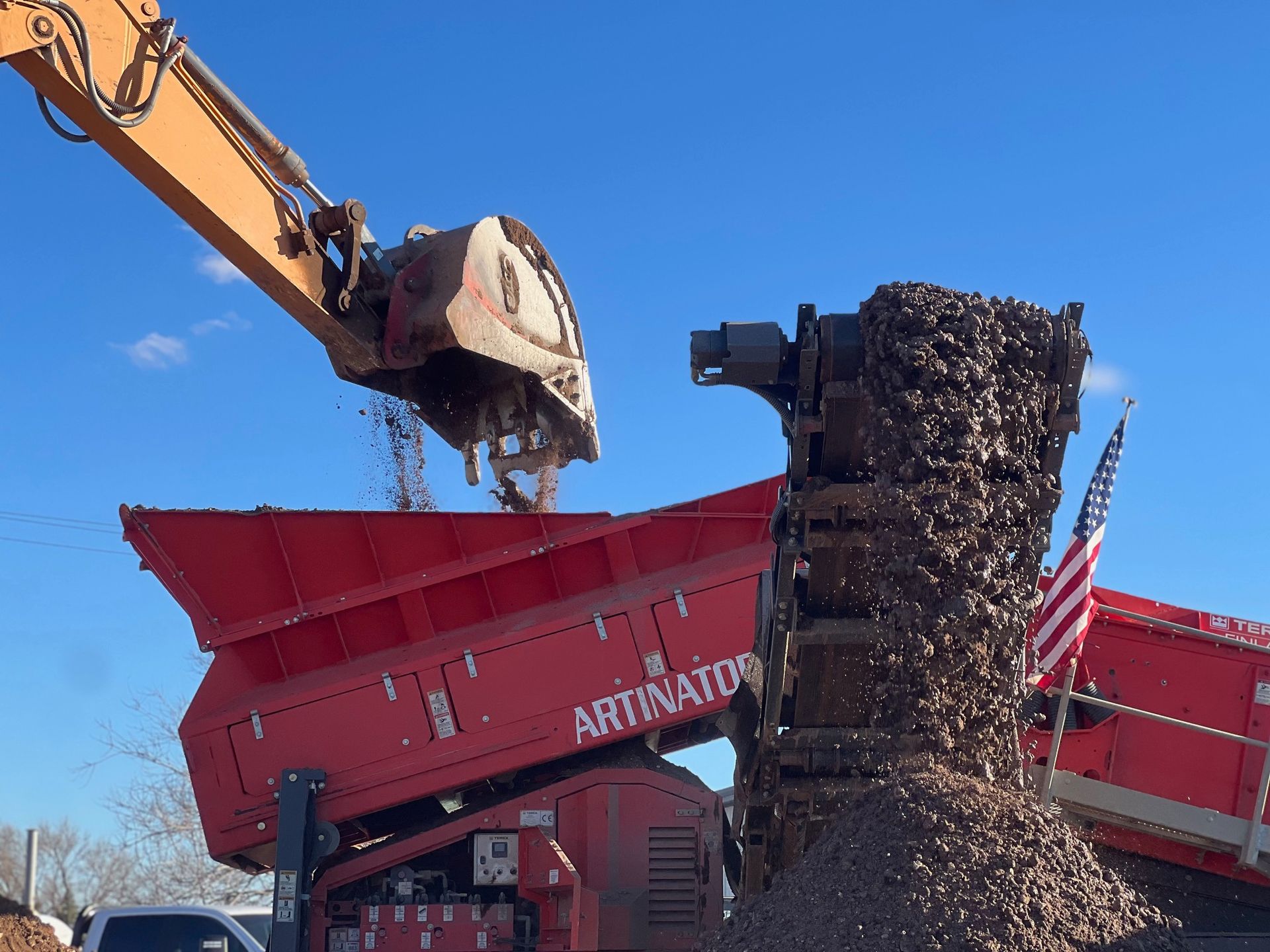 A large pile of gravel is being poured into a machine.