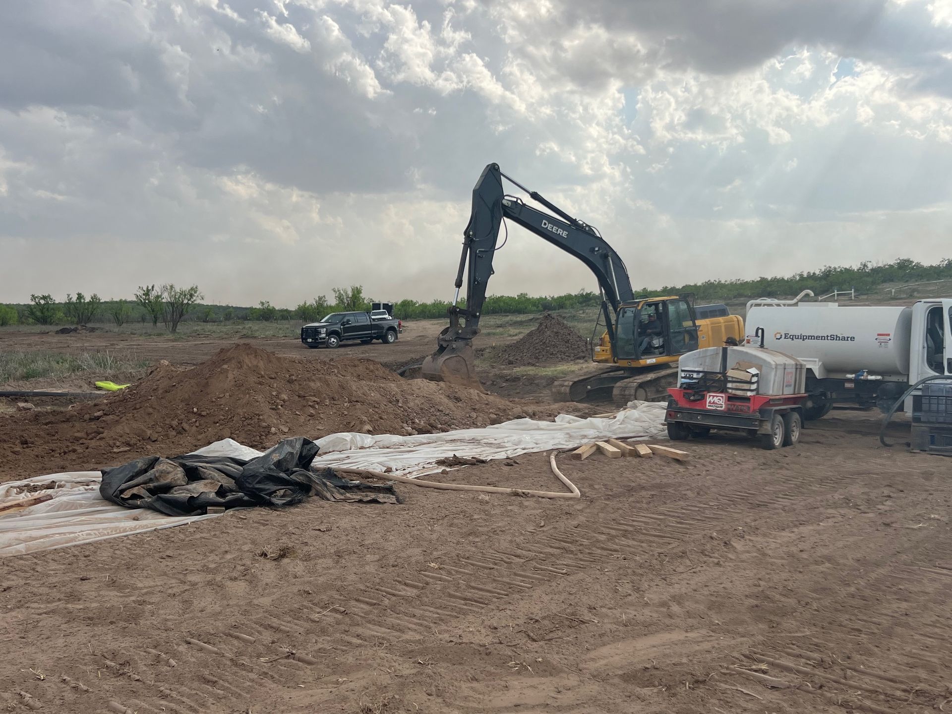 A large excavator is digging a hole in a dirt field.