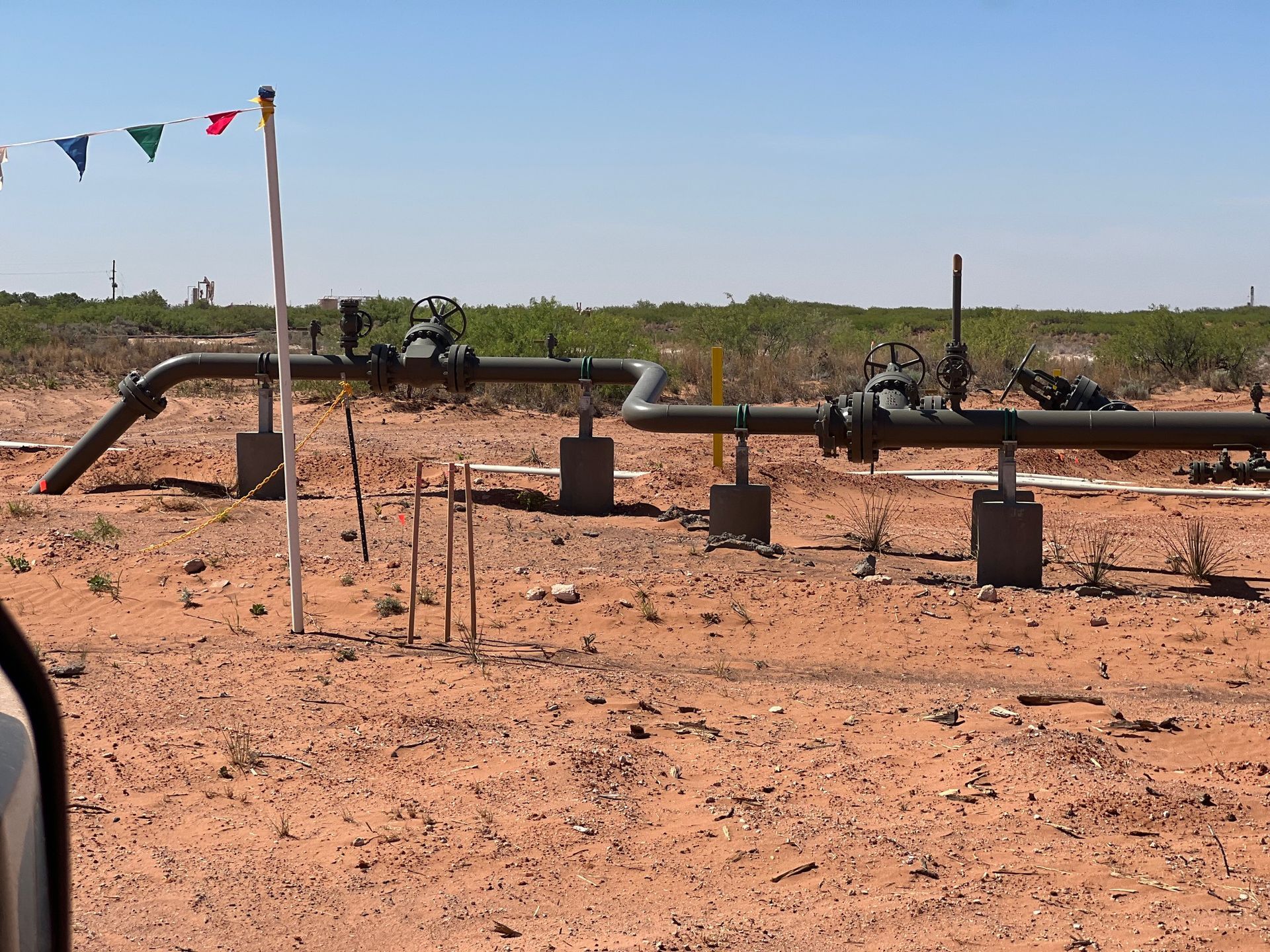 A row of pipes in the middle of a dirt field