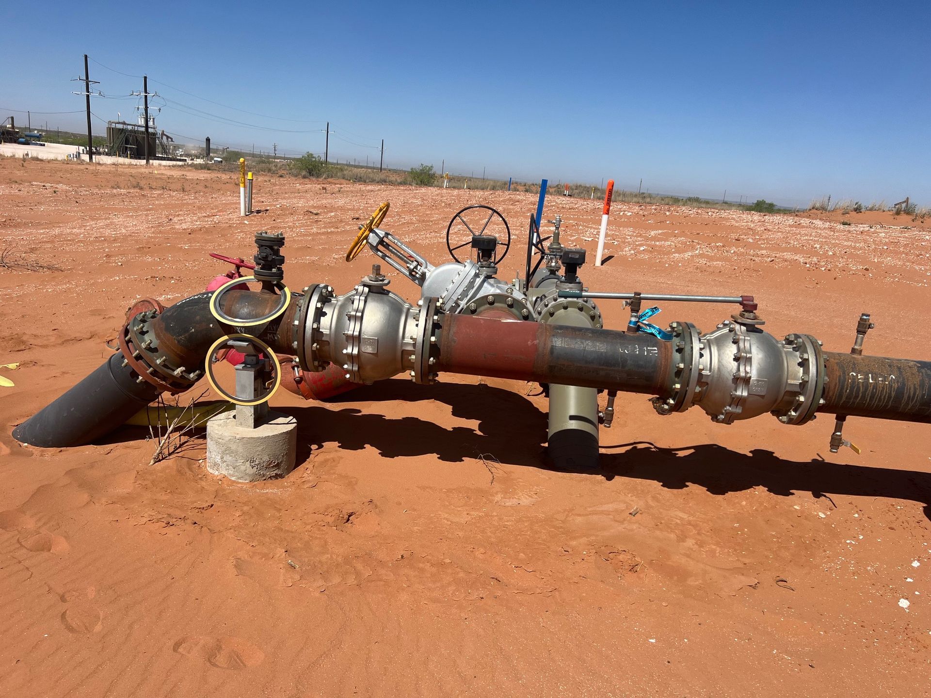 A bunch of pipes are laying in the dirt